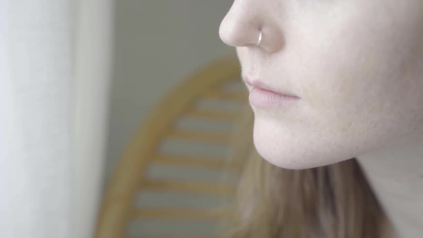A woman with a nose ring looking out of a window