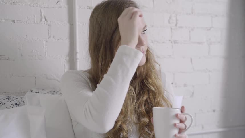 A woman takes a sip from a coffee mug
