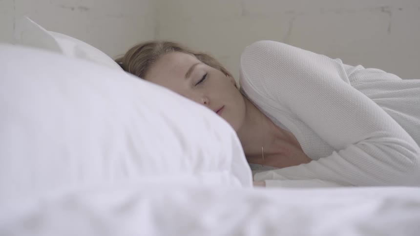 A young woman lies in a bed