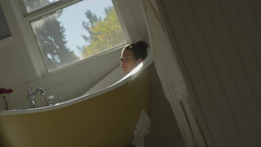 A woman is relaxing in a bathtub