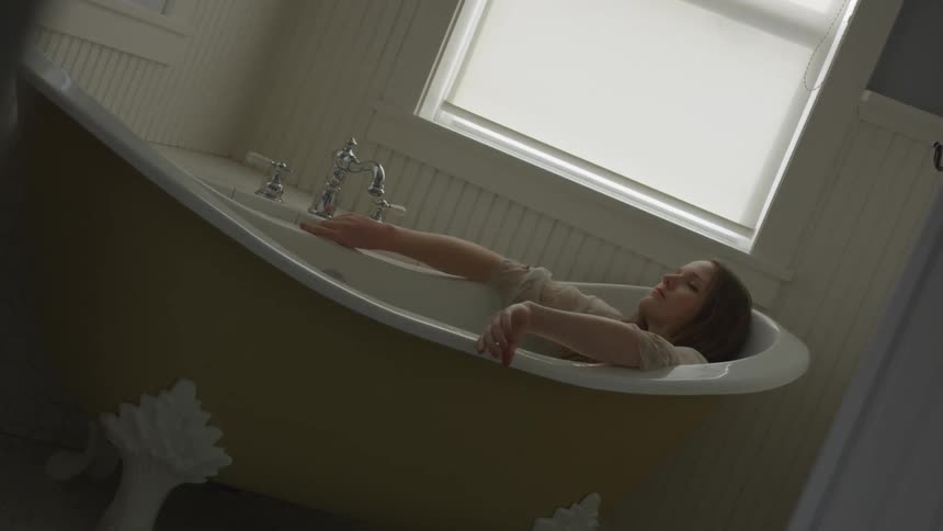 A woman is resting in the bathtub