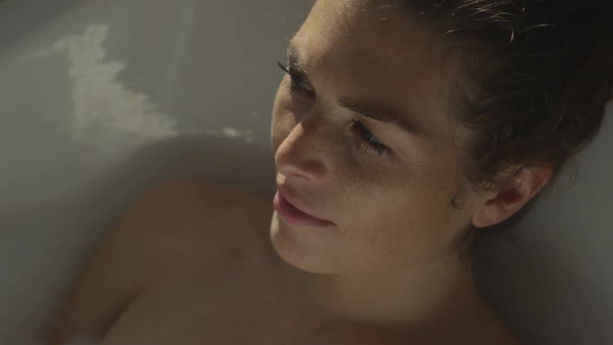 A woman is resting in the bathtub