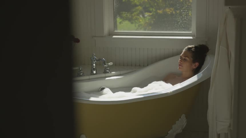 A woman is in a bathtub relaxing