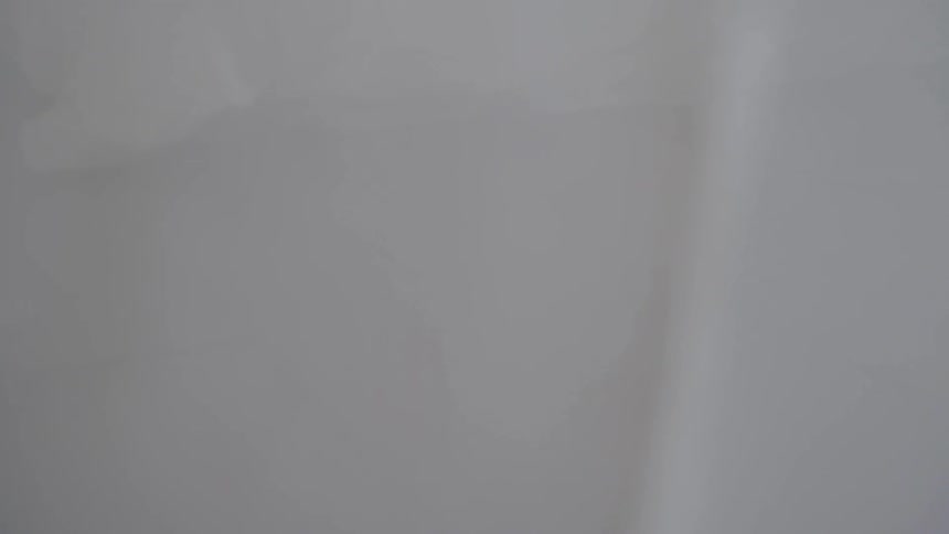 A person walks behind white curtains