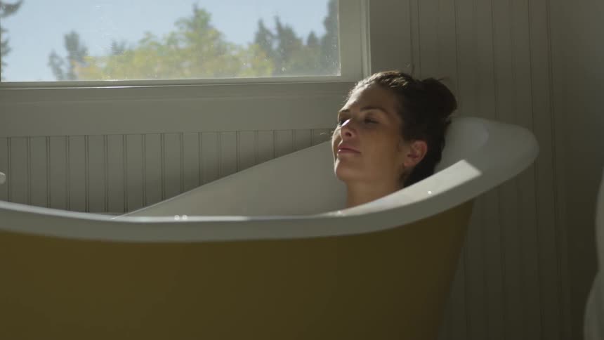 A woman sits in a bath relaxing