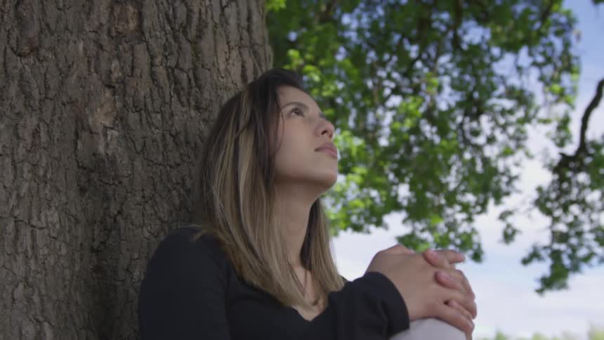 Girl sitting next to a tree