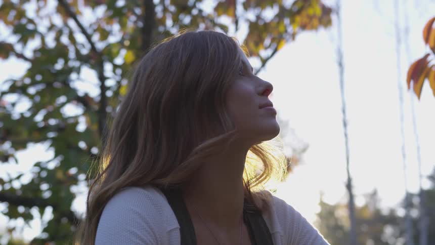 Young blonde woman in profile looking up outdoors in daytime