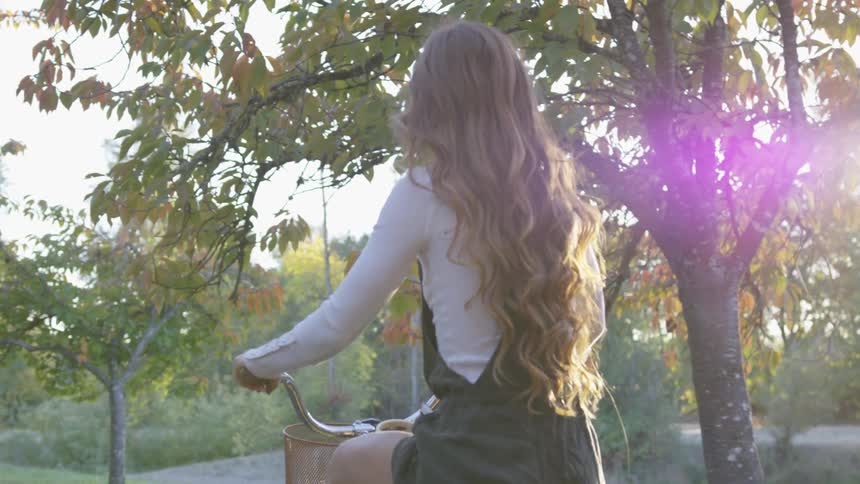 A woman with long hair rides a bike