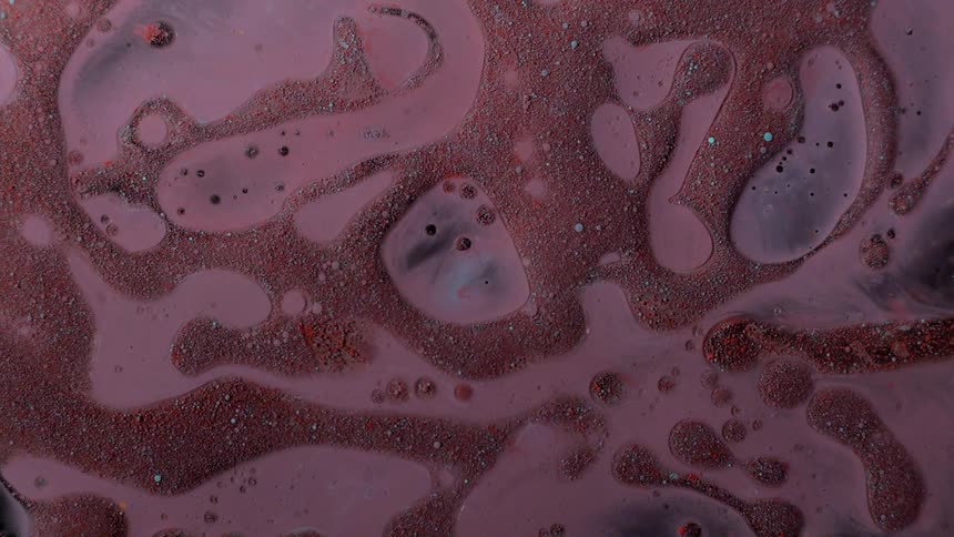 Swirls of red are in a pink body of water