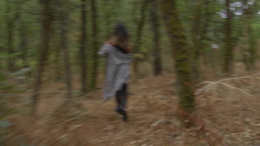 A black woman running through a wood