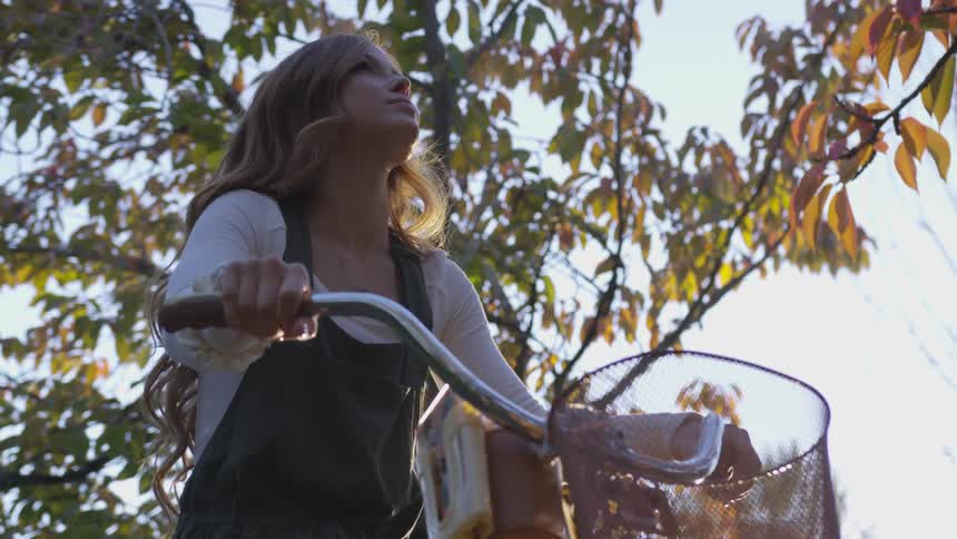 A girl sits on her bike looking around