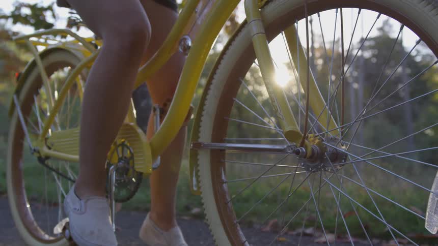A woman sits on a bike on a path
