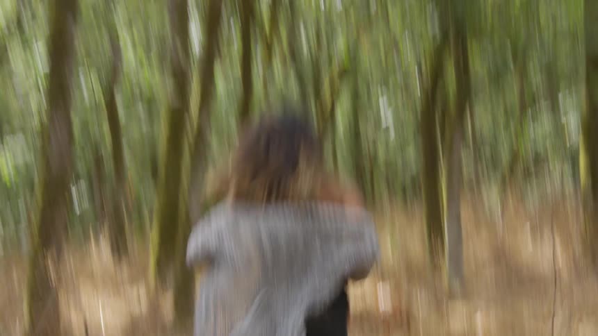 A woman is racing through the forest