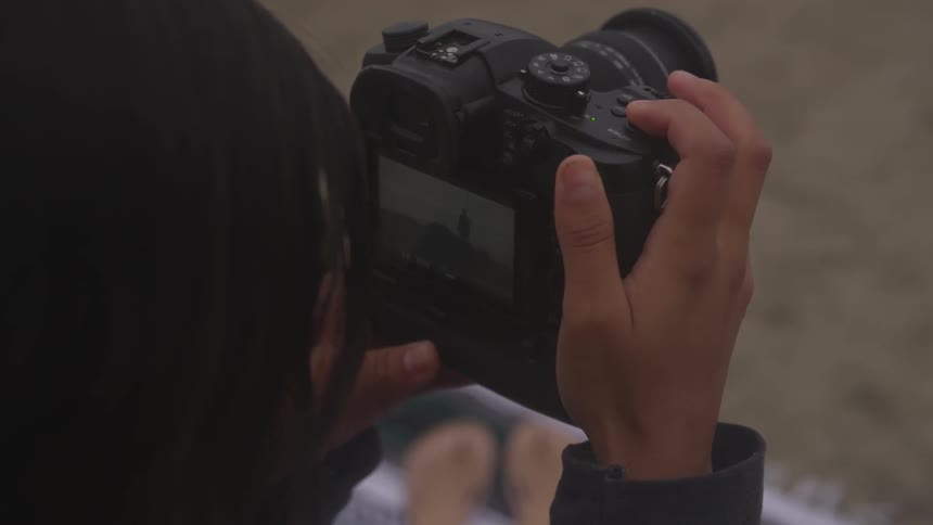 A person holding a video camera and observing footage