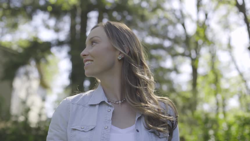 A woman looking around in a forest