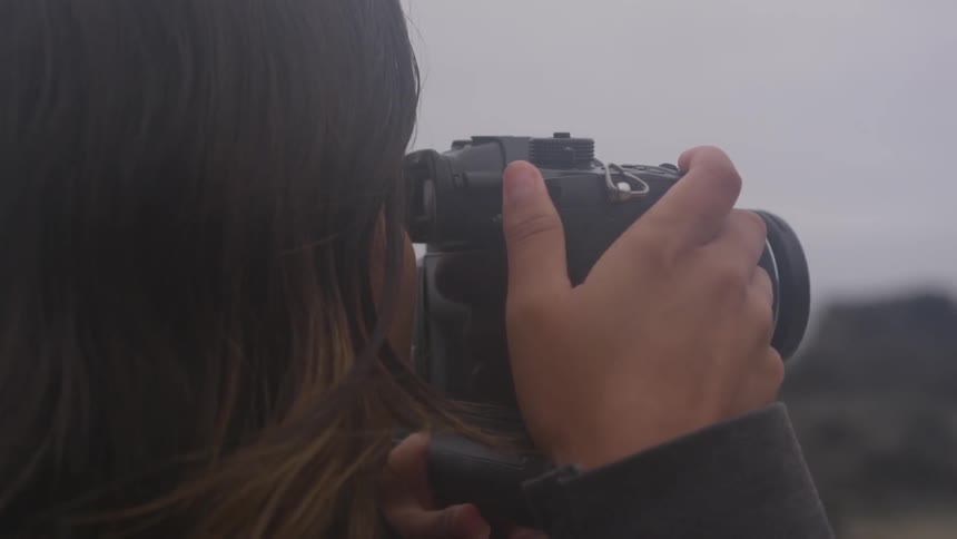 A female photographer taking photographs outdoors