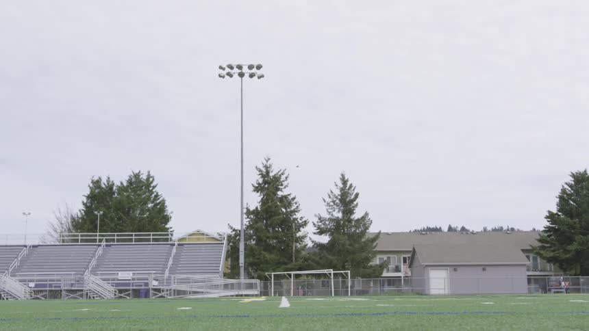 A woman running drills in an outdoor field
