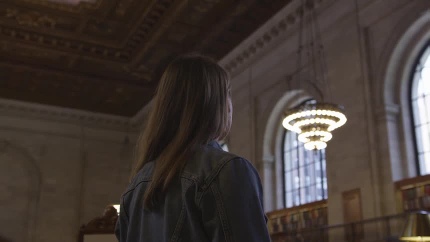 A woman looking towards the ceiling in the library