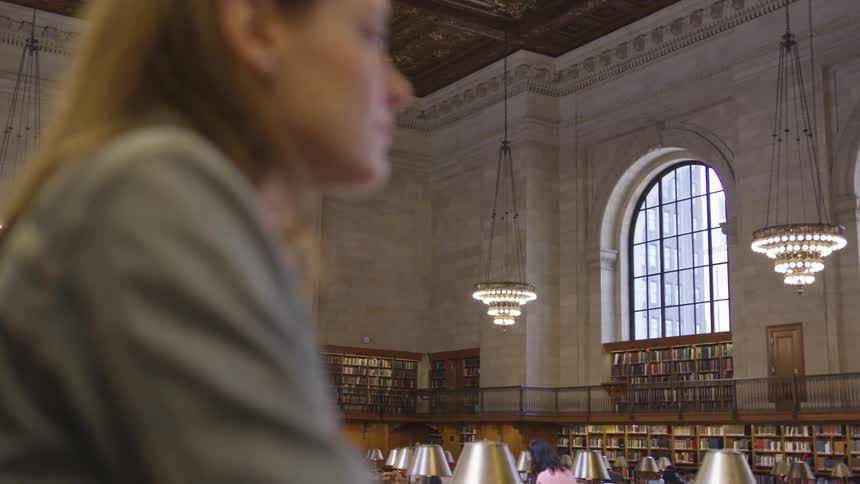 A young woman sits in a library