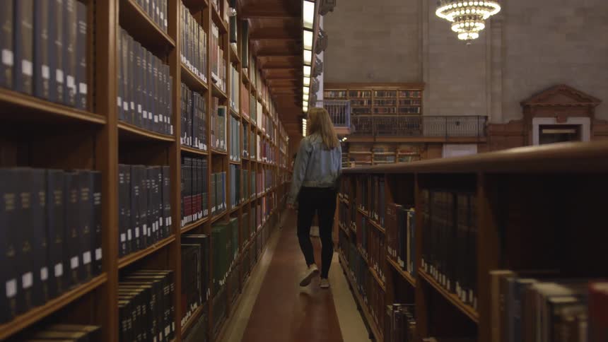 Woman walks through large college library