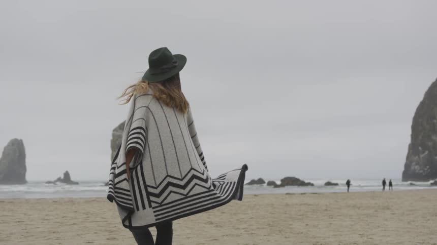 Girl spinning around near a beach