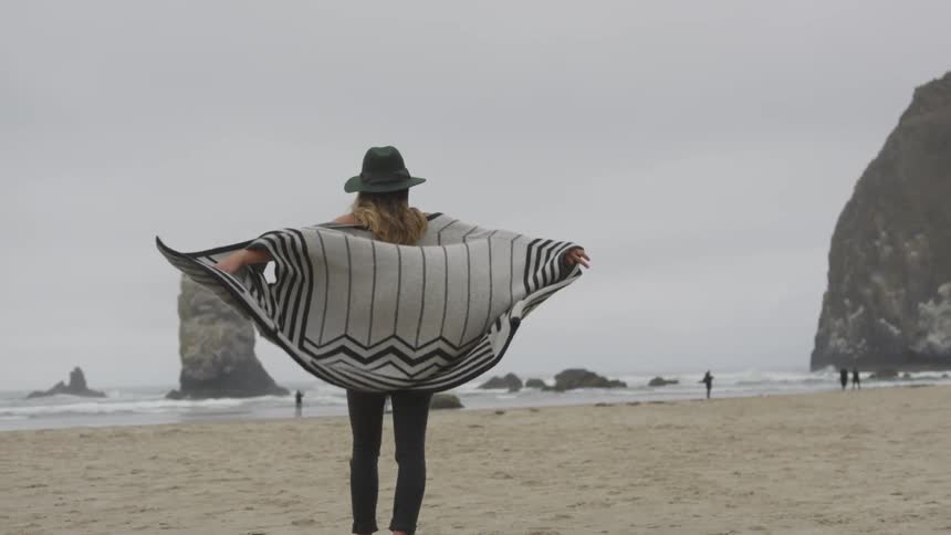 A young woman walks along a beach