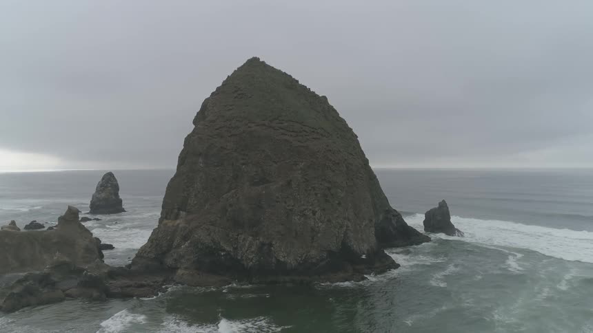 Tall rock formation at the seashore on a cloudy day