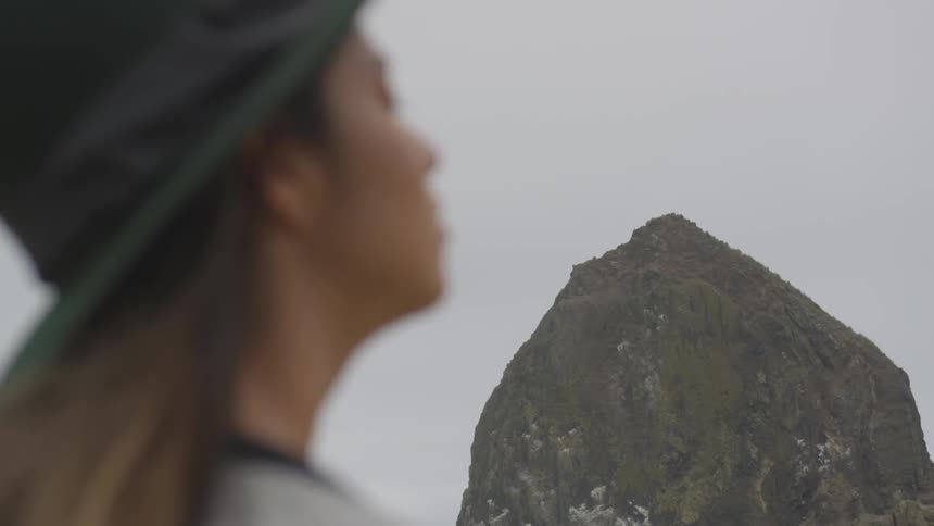 Person looks towards the sky with a mountain in the background