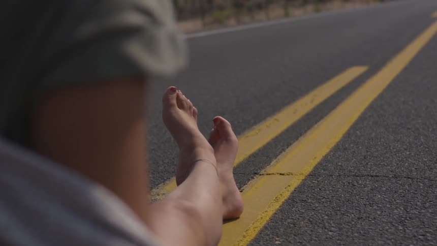 Person sitting cross legs on the road