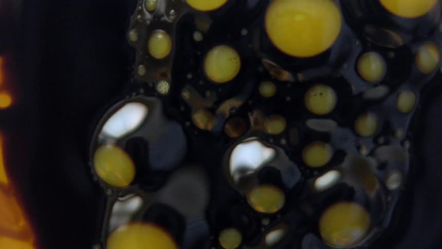 Black liquid with small yellow spots in it