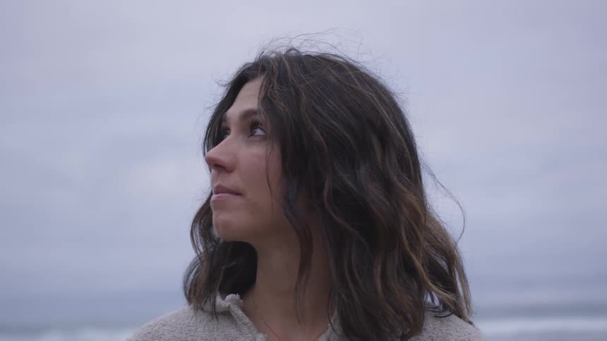 A woman is standing outside and looking up