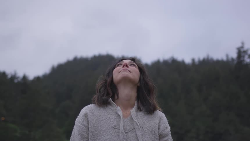 Woman looking up to the sky and smiling