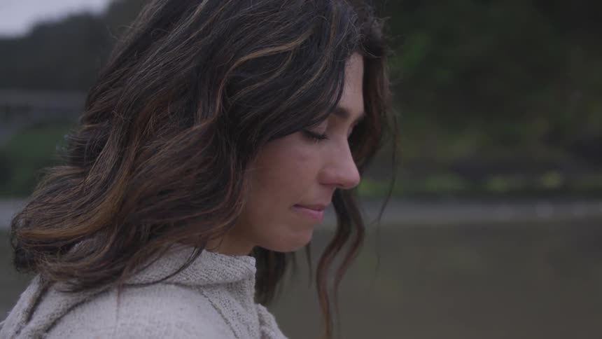 A caucasian woman standing outside with her eyes closed