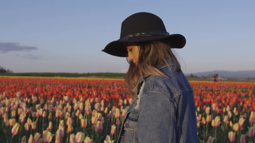 A woman walking the a field of flowers