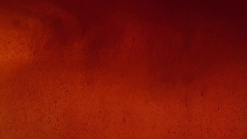 Reddish fluid flowing downward slowly against a red background