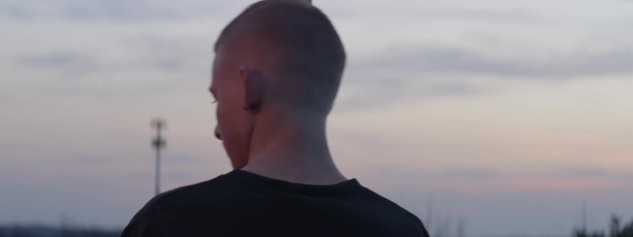A man is outdoors at dusk