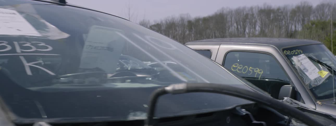 Boy walking through a junkyard of cars