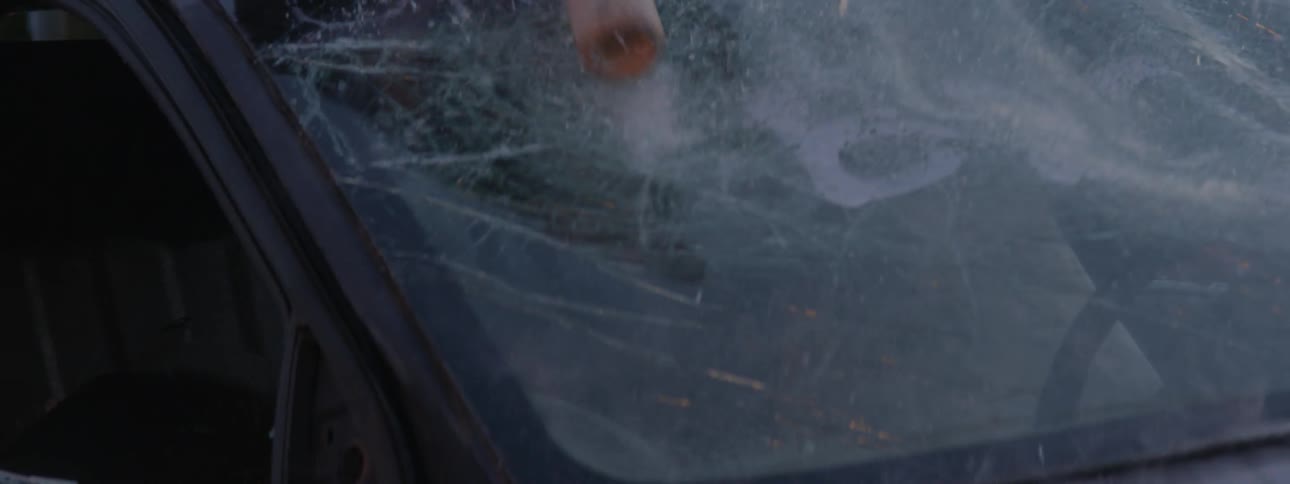 A teenager beating a car with a bat