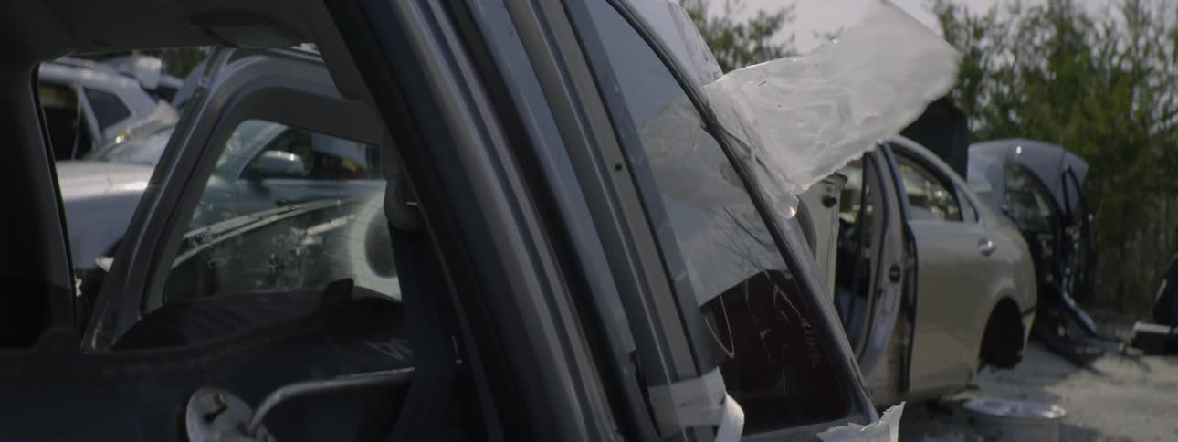 The wind blows the plastic on the vehicle in the lot