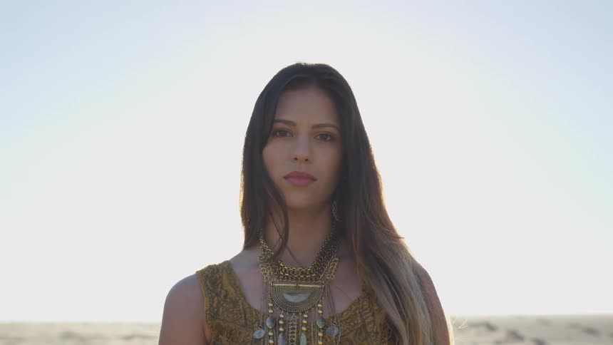 A woman is standing in a field on a sunny day
