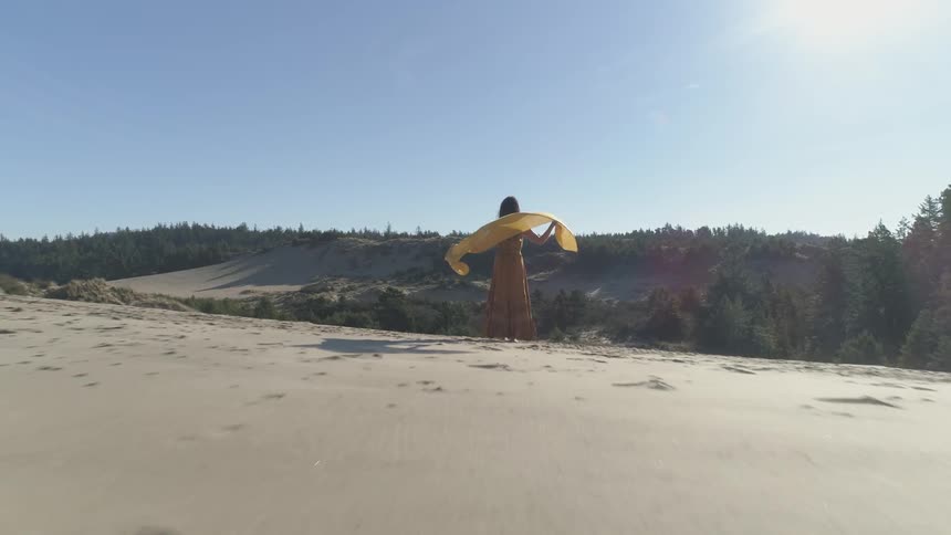 A woman is standing in a desert area