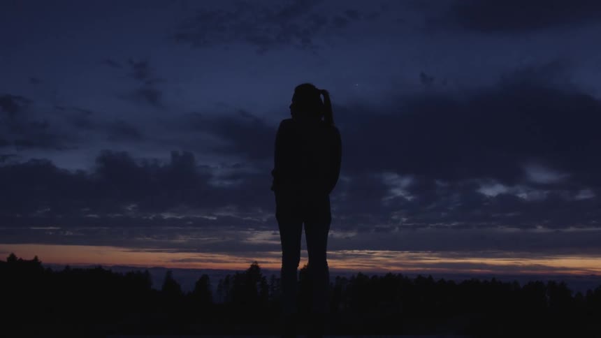 A woman standing at the top of a hill