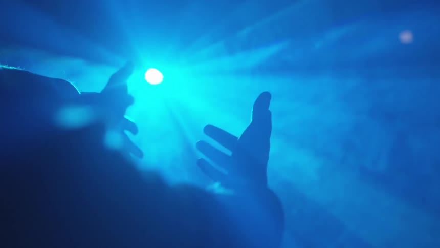 A person dancing in front of a laser