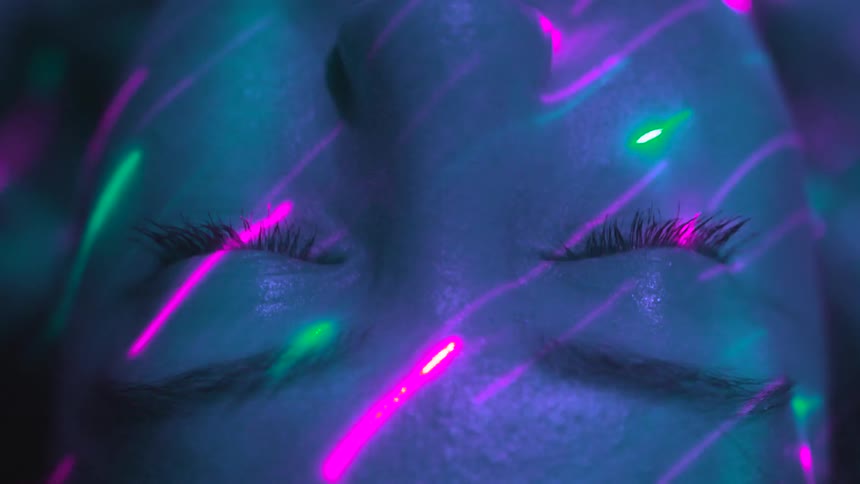 A person laying around with lasers on their face