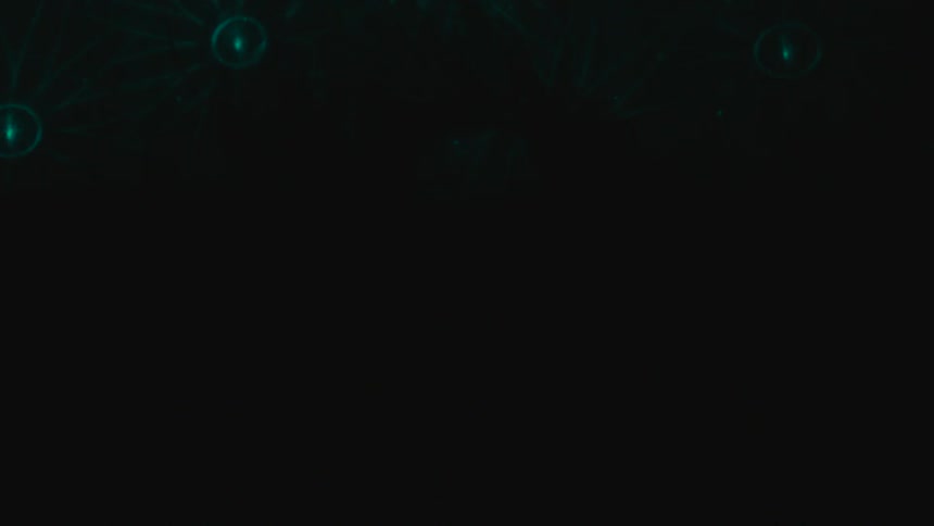 A woman lays with her eyes closed as sparkling lights and other celestial images are projected onto her and the ground beneath her