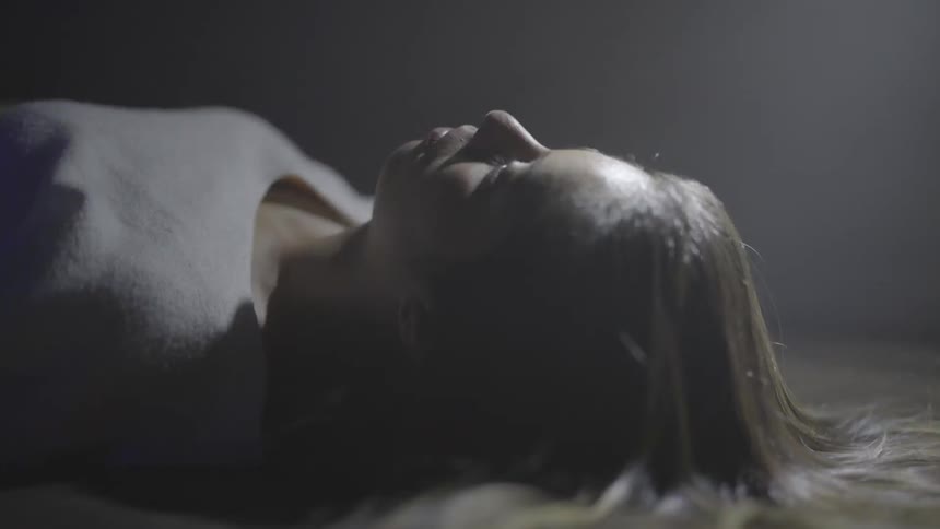 A woman lays down near a blinking light