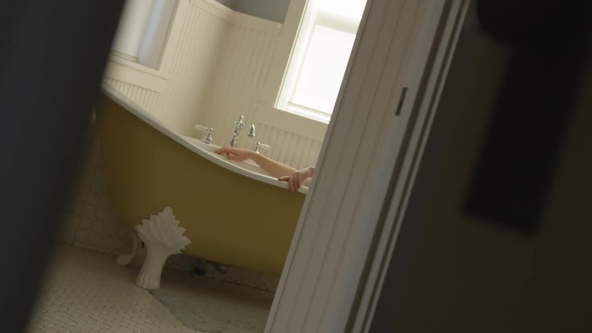 Camera shows hands of a woman taking bath
