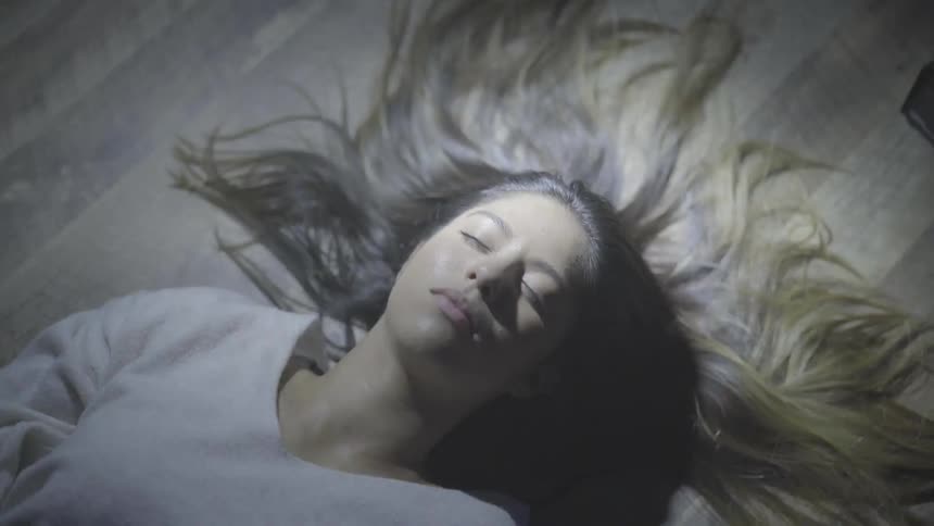 A woman laying down on the floor with lights flashing on and off