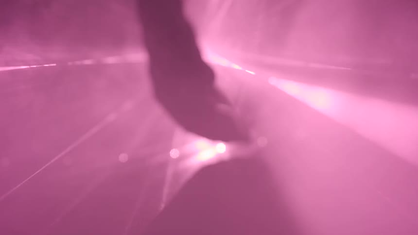 A fist clenching and unclenching in front of strobe lights