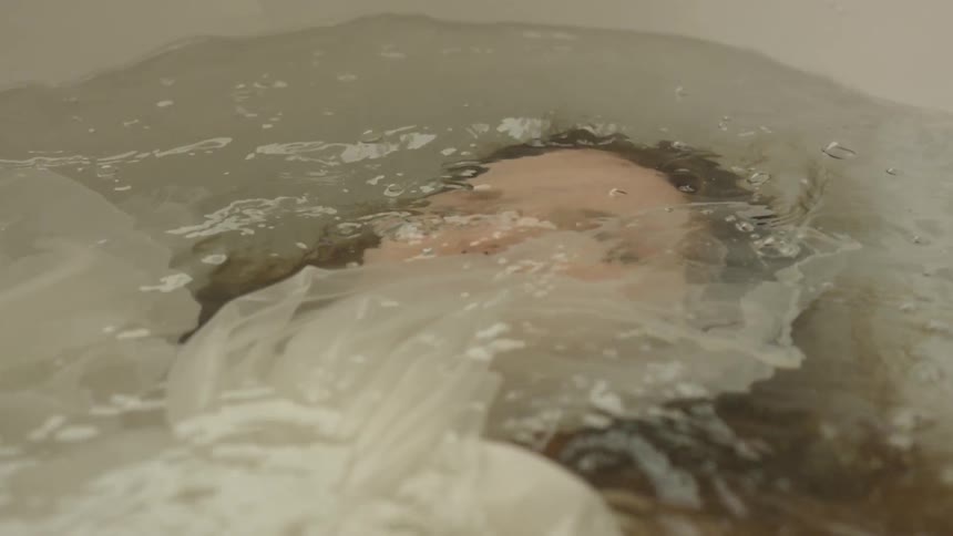 Woman submerged in bathtub